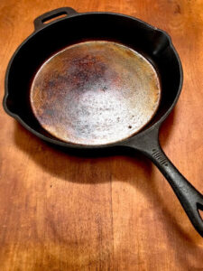 a restored cast iron skillet on a wood table