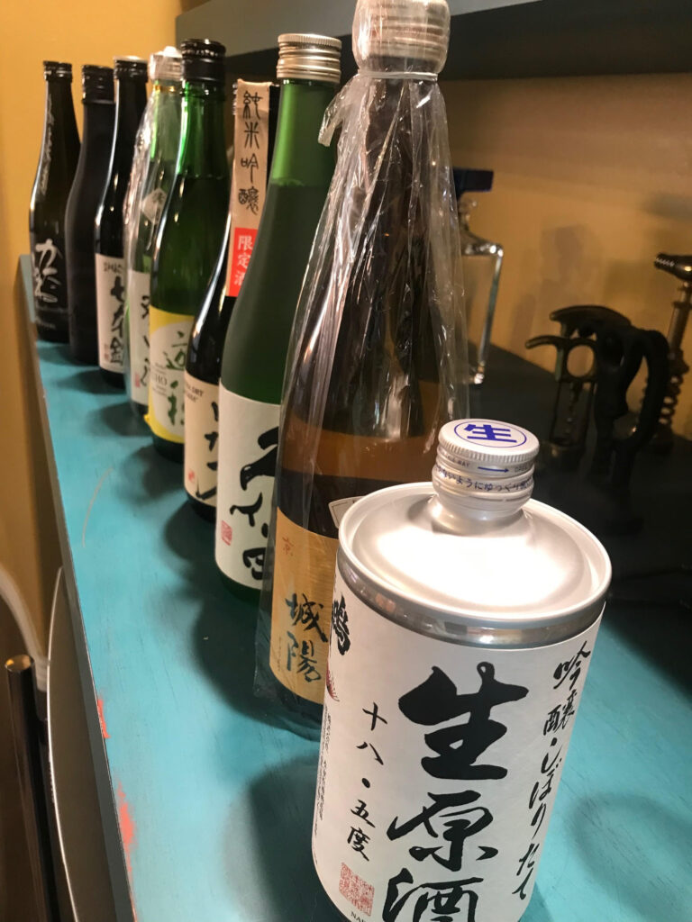 A collection of bottles and cans of Japanese sake