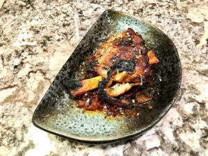 roasted pork wings or pig wings or pork shank on a half-moon-shaped plate