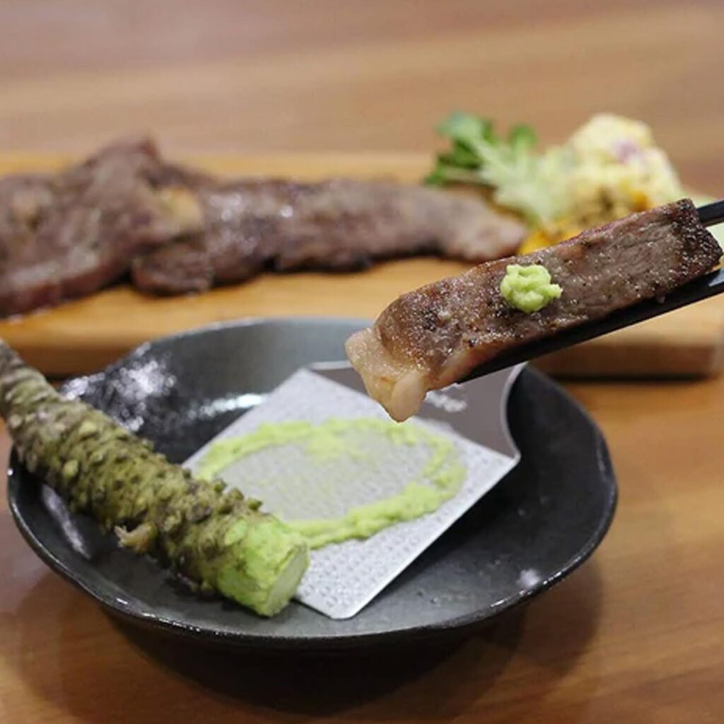 photo of grated wasabi root on a piece of grilled meat