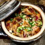 a Japanese donabi hotpot full of chicken, vegetables, and broth