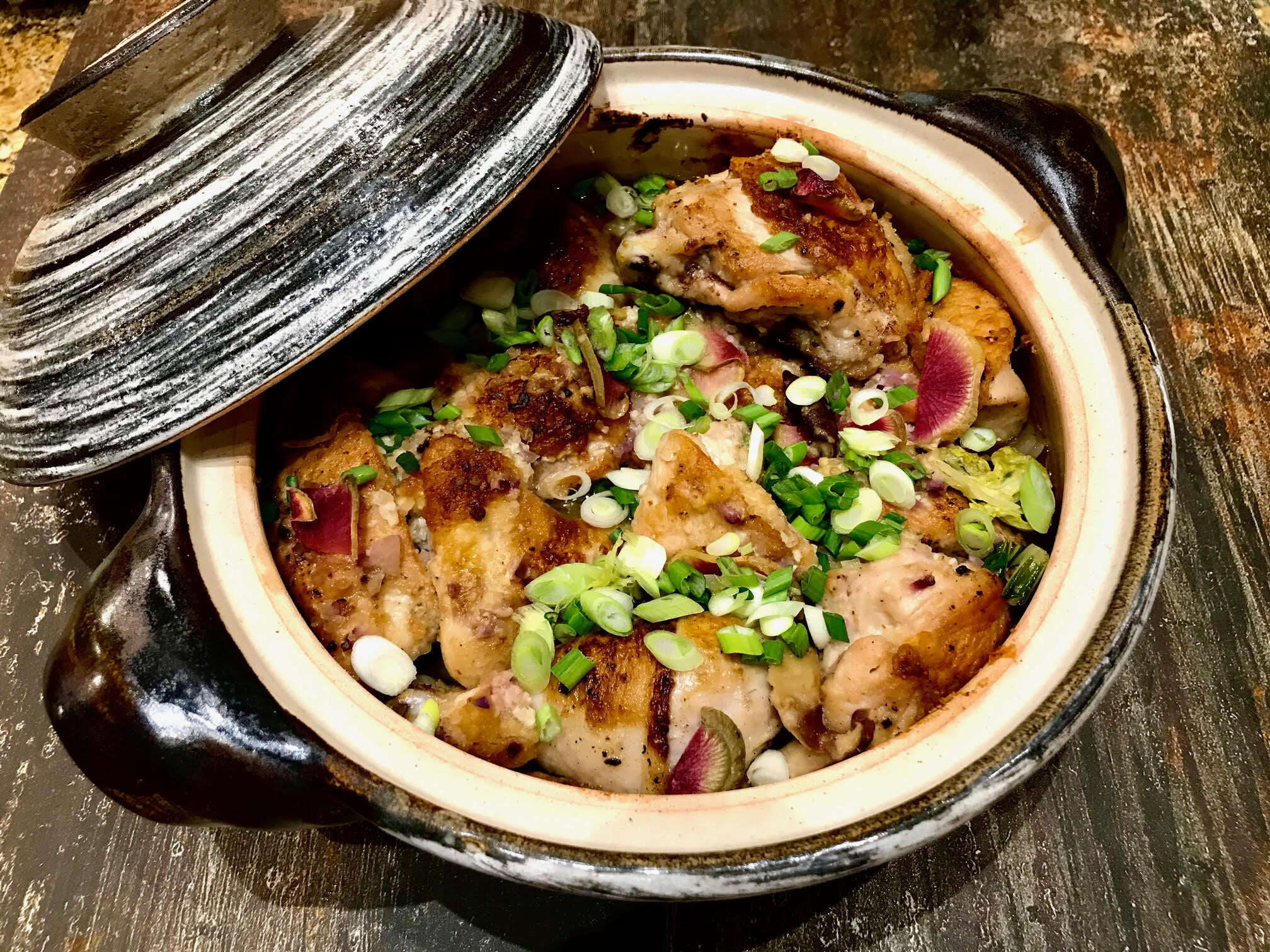 a Japanese donabi hotpot full of chicken, vegetables, and broth