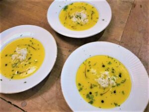 three bowls of a yellow colored soup called "leopard soup"