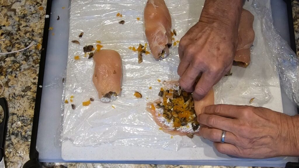 rolling up chicken roulade rollups stuffed with goat cheese, mushrooms, and apricots
