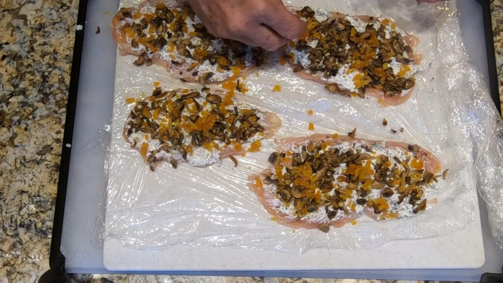 topping pounded chicken breasts with a a goat cheese mixture, sauteed mushrooms, and chopped dried apricots