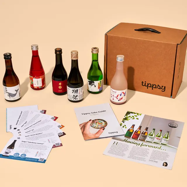 photo of several sake bottles, a Tippsy Sake branded sake box, and a sake guide