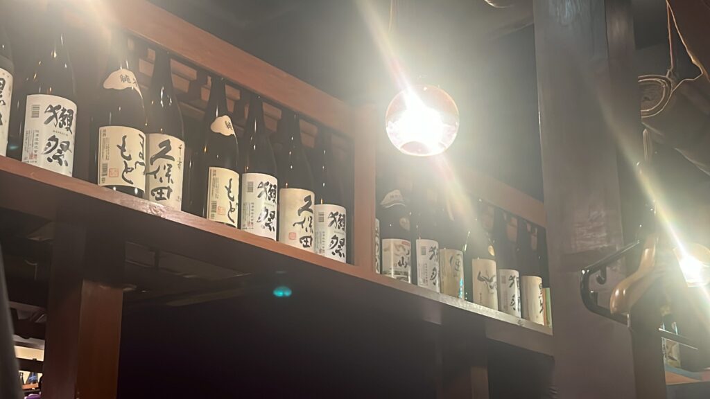 a row of sake bottles on a shelf