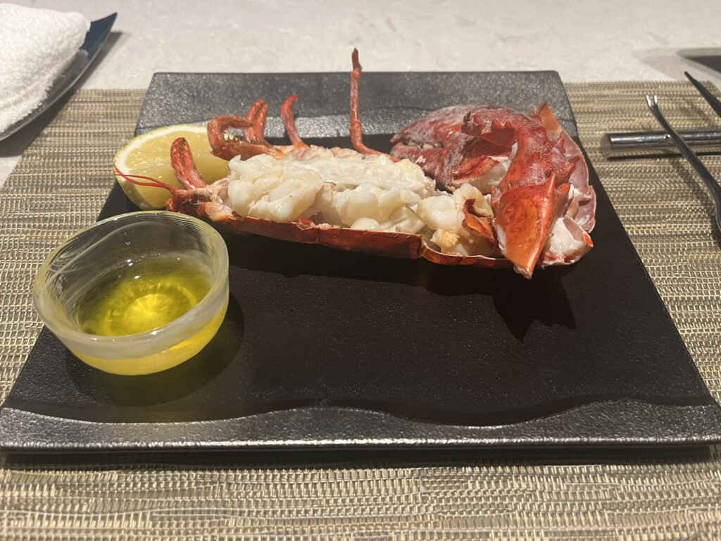 cooked lobster pieces in the shell with a small bowl of butter