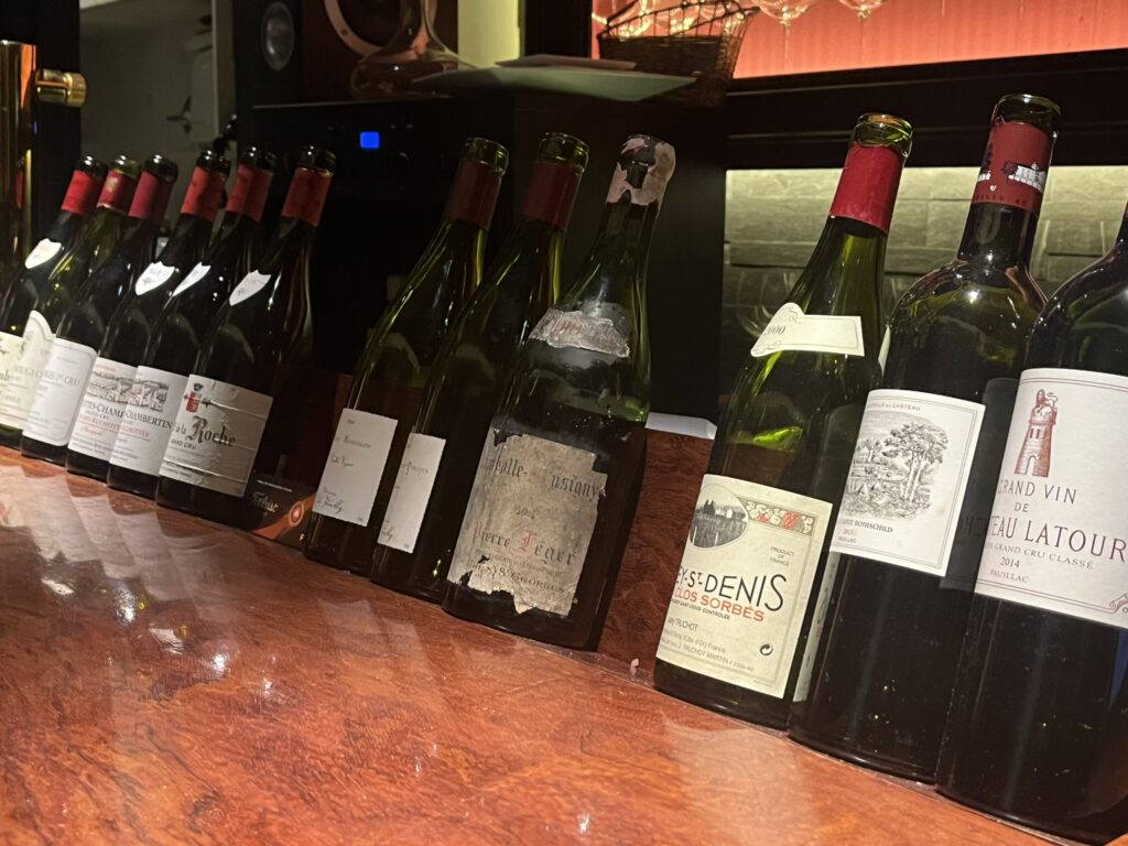 several bottles of Burgundy red wine on a shelf