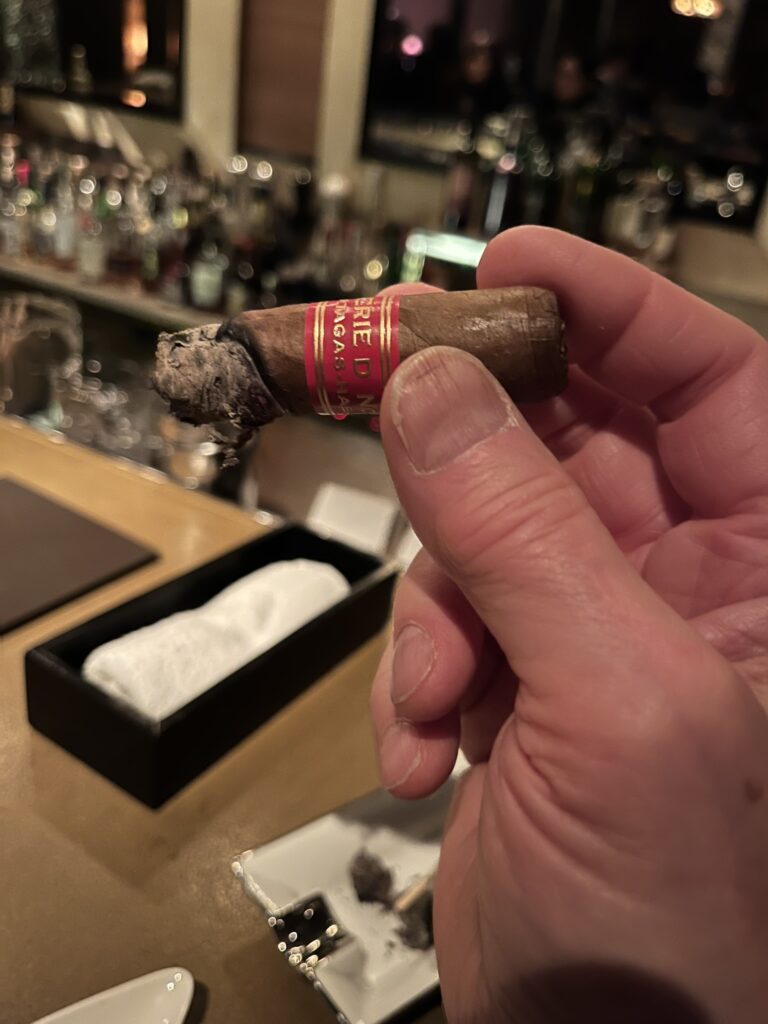 hand holding a mostly smoked Partagas Serie D cuban cigar