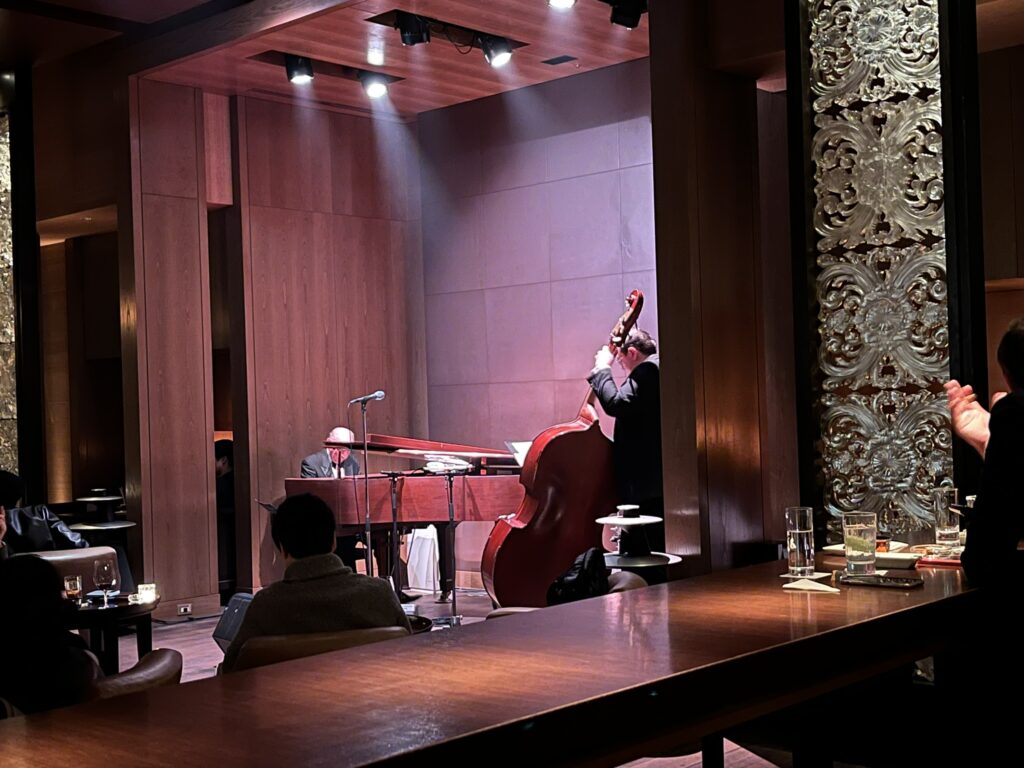 a man playing piano and a man playing bass in an alcove of a jazz club in Tokyo