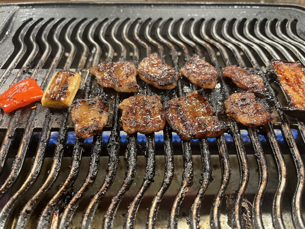 Beef and vegetables cooking on a Yakiniku grill