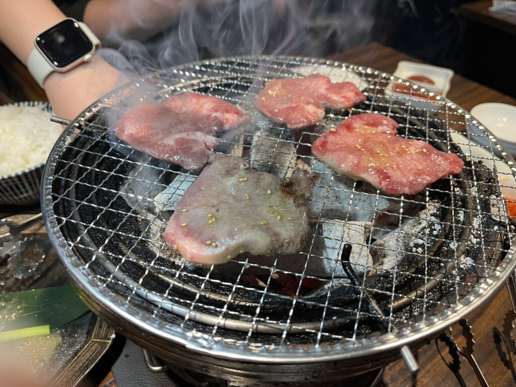Grilling beef on a charcoal grill in the Sumibi-Yakiniku Niku-bal-sanchome Yakiniku restaurant in Osaka Japan