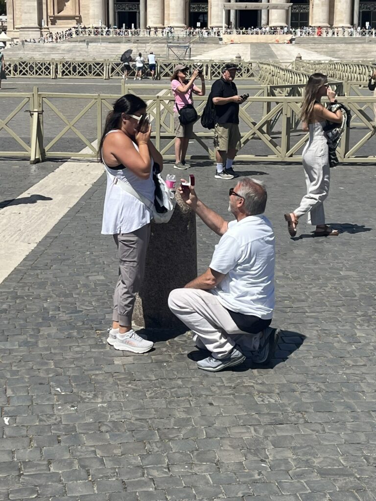 a man on one knee proposing to a woman in St. Peter's Square in Rome Italy