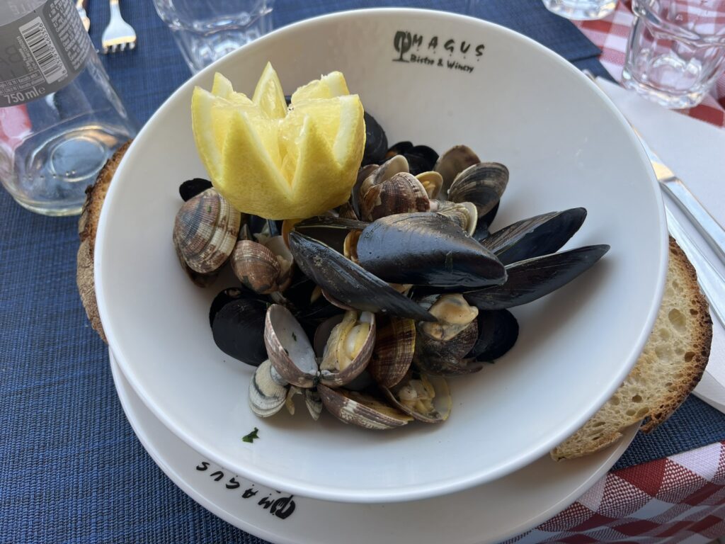 sautéed mussels and clams with a lemon in a white Magus bowl