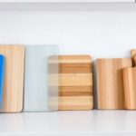 a collection of cutting boards made of various materials including wood, plastic, and glass