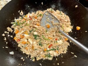 fried rice in a wok with a wok spatula