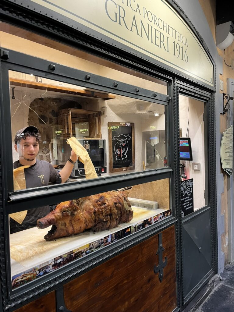 a man carving a roasted pig at Antica Porchetteria Granieri 1916 in Florence Italy