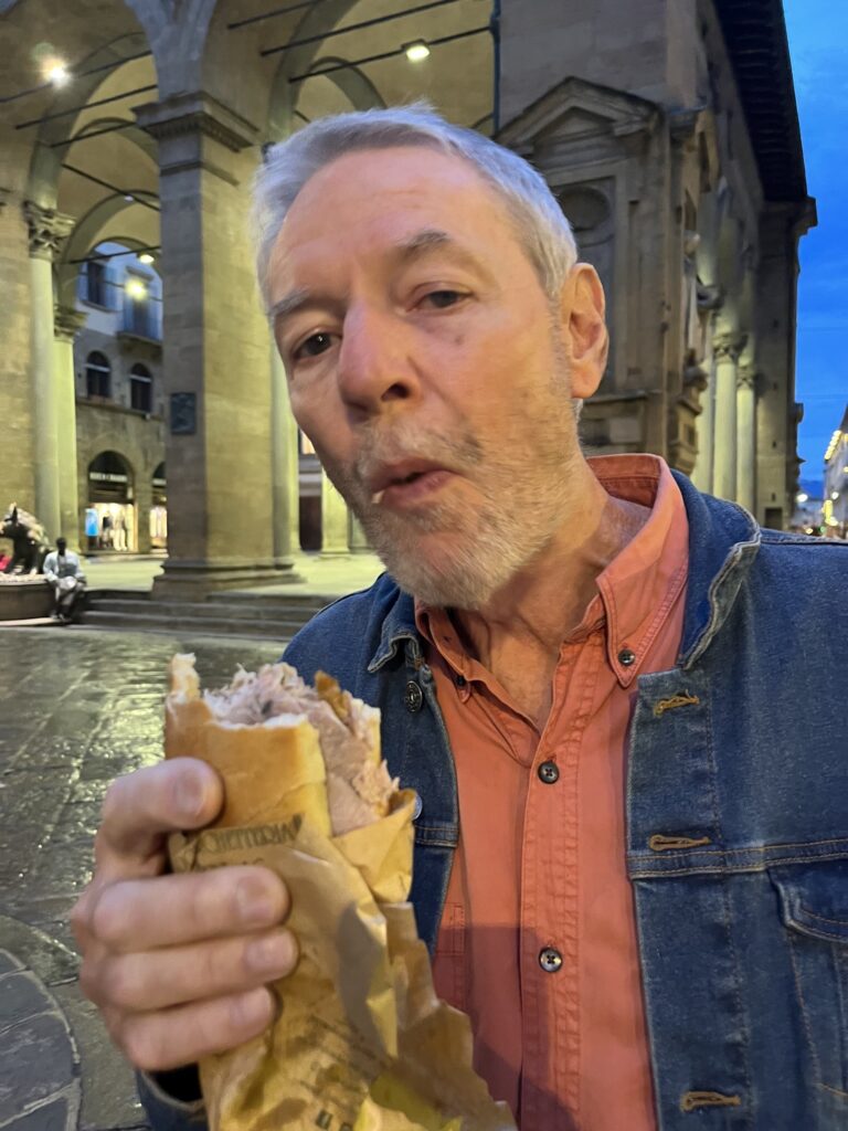 the author John Hornick eating a sandwich of roasted pork wrapped in paper