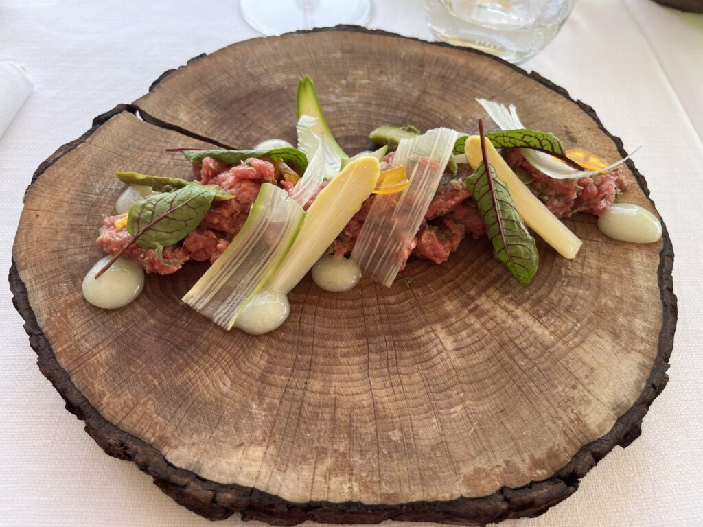 beef tartare plated on a slice of a tree