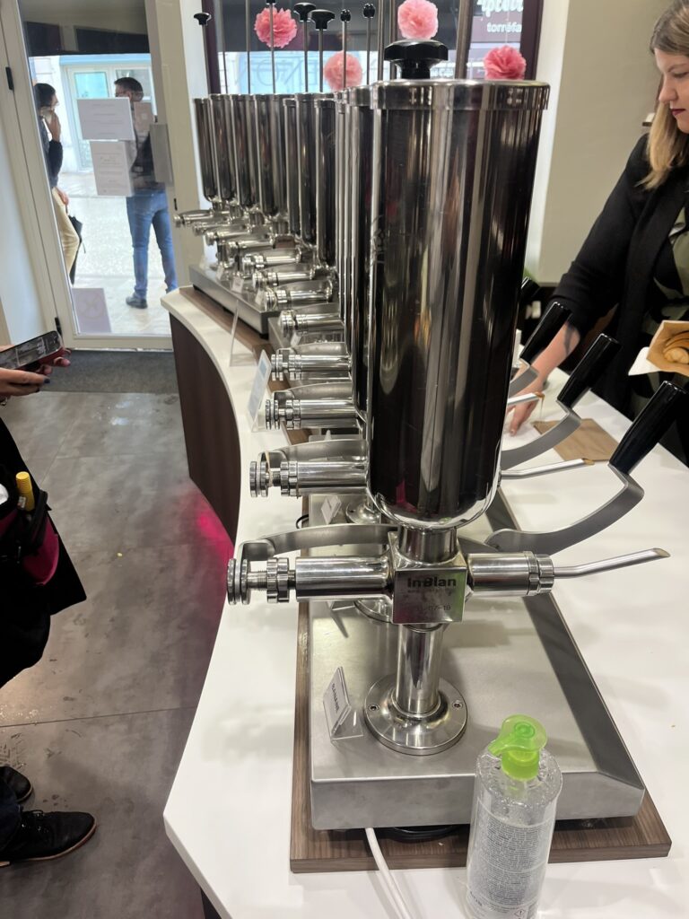 a row of machines for injecting flavored cream into croissants, end view