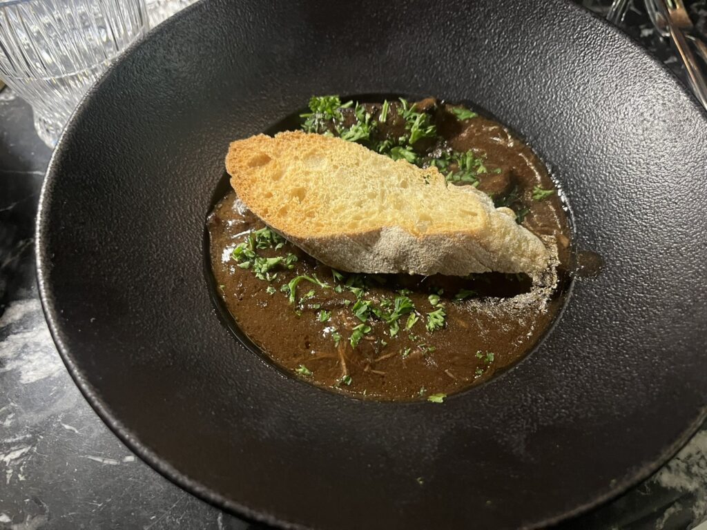 a bowl of Oeuffs Meurette at Speakeasy restaurant in Dijon France